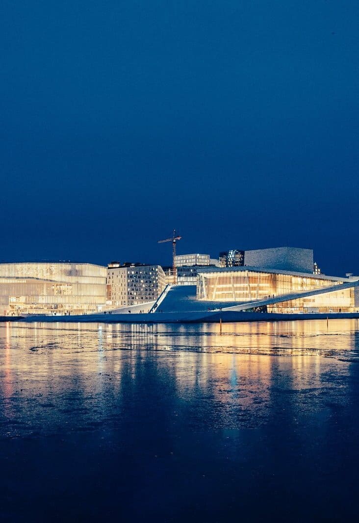 white concrete building near body of water during night time